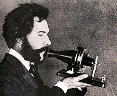 Alexander Graham Bell spricht in ein Telefon