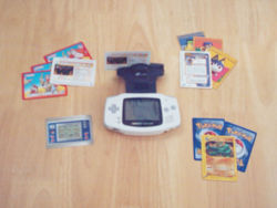 Ein Game Boy Advance mit aufgestecktem Nintendo e-Reader und verschiedenen e-Cards